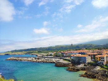 Scenic view of sea by buildings against sky