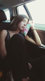 Young woman sitting in car