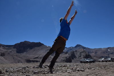 Man skateboarding on mountain against sky