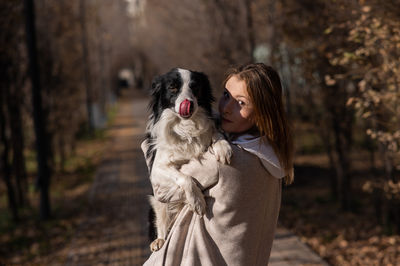 Portrait of young woman holding dog
