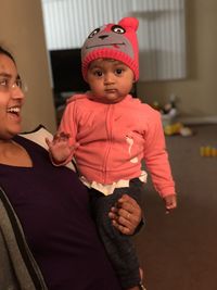 Mother carrying daughter at home