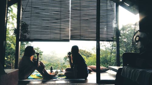 People enjoying food and drink while sitting by glass window
