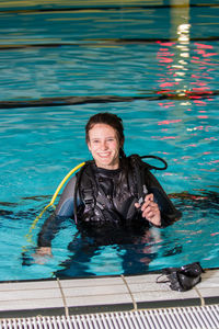 Portrait of smiling young woman in swimming pool