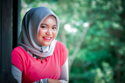 Portrait of smiling young woman standing outdoors