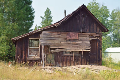 Old wooden house on field