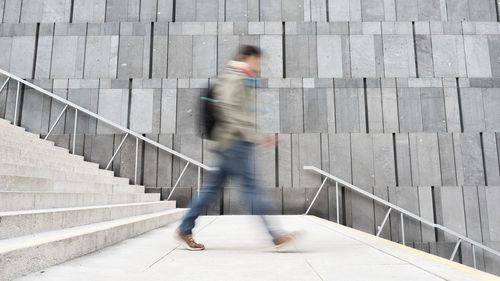 Blurred motion of man walking on staircase
