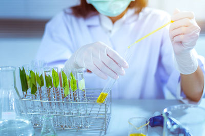 Scientist examining yellow chemical in laboratory