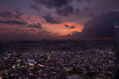 High angle view of illuminated cityscape against sky during sunset