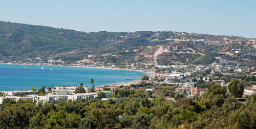 Scenic view of sea and buildings against clear sky