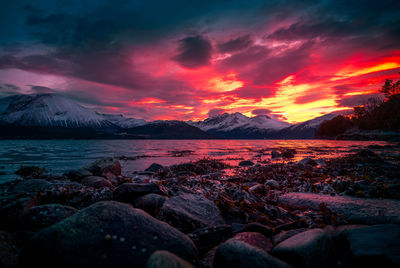Scenic view of sea against dramatic sky during sunset