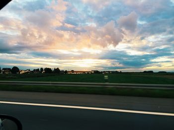 Country road against cloudy sky