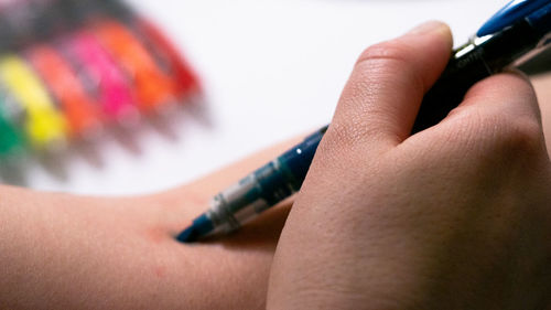 Close-up of hand injecting pen