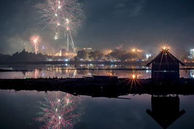 Firework display over illuminated city at night