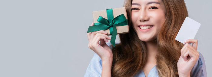 Portrait of a smiling young woman against white background