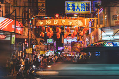 Crowd in illuminated city at night