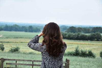 Rear view of woman standing on field