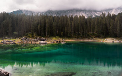 Scenic view of lake by mountains against sky