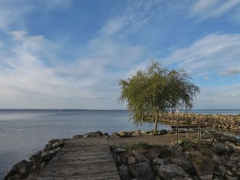 Scenic view of calm sea against cloudy sky