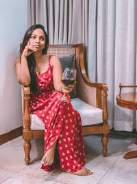 Portrait of young woman sitting on sofa at home