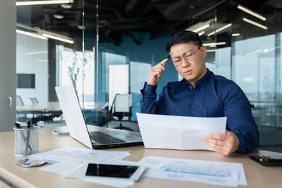 Businesswoman using laptop at office