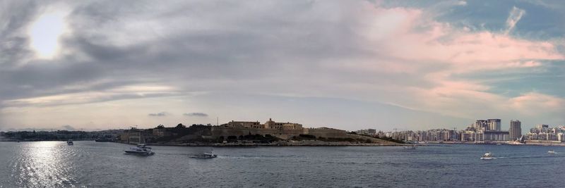 Panoramic view of sea and buildings against sky