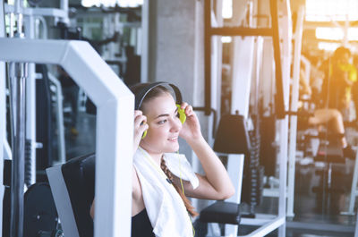 Woman wearing headphones while exercising in gym