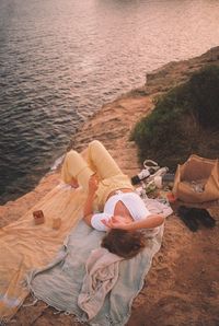 High angle view of a girl picnicing at the ocean 