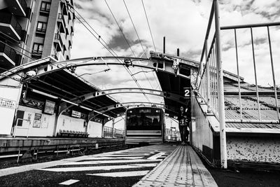 Railway bridge in city against sky