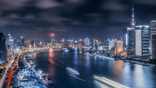 Illuminated buildings in city against sky at night