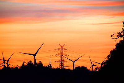 Low angle view of silhouette plants against orange sky