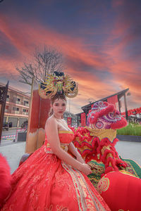 Portrait of young woman standing against sky