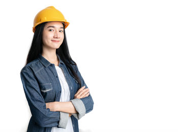 Portrait of smiling young woman standing against white background