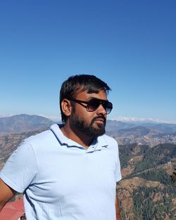 Young man standing against mountains