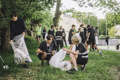 Boys collecting garbage in plastic bags