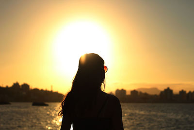 Silhouette of woman looking at sunset