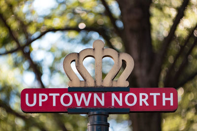 Close-up of road sign against sky