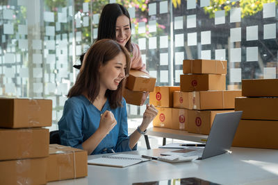 Side view of woman using laptop while sitting on table