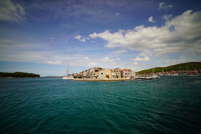 Scenic view of sea by buildings against sky