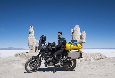 Woman sitting on her adventure touring bike at salinas grandes / jujuy