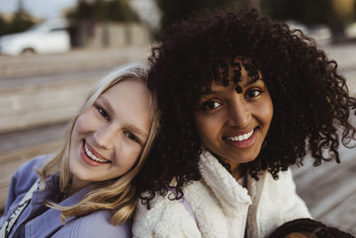 Portrait of smiling female friends on pier