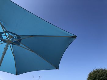 Low angle view of umbrella against clear blue sky