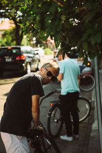 Rear view of man riding bicycle on street