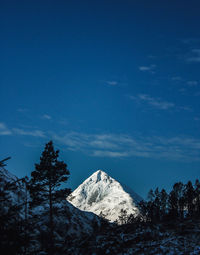 Scenic view of snowcapped mountains against blue sky