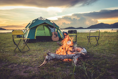 Campfire by tent on field