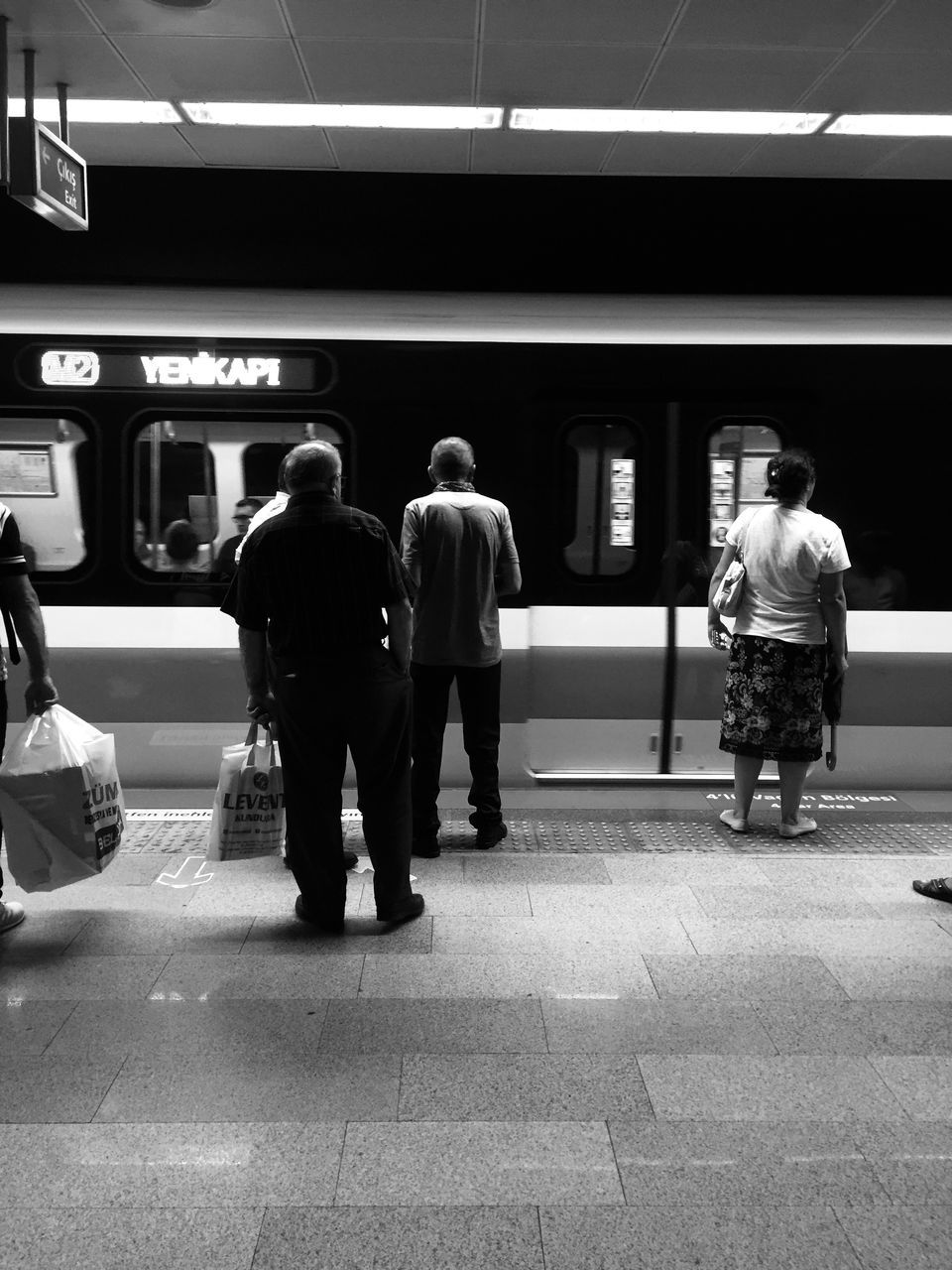 transportation, public transportation, mode of transportation, group of people, rail transportation, real people, subway station, architecture, city, men, travel, train, waiting, rear view, full length, motion, adult, people, train - vehicle, subway train