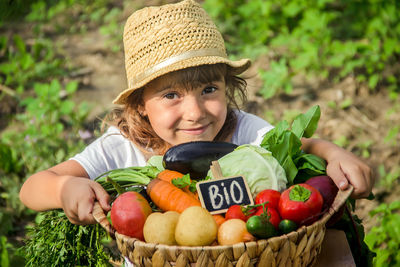 Portrait of cute boy with vegetables in basket