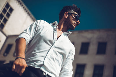 Low angle view of young man wearing sunglasses