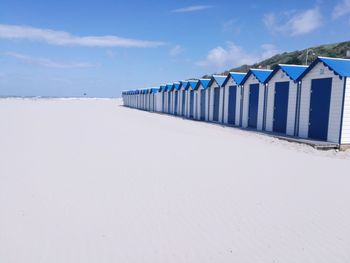 Beach huts against sky during sunny day