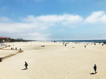 People at beach against sky