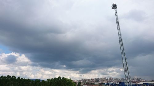 Low angle view of cranes and buildings against sky